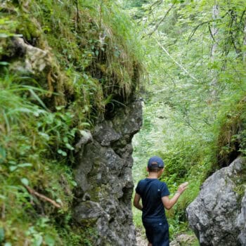 Kind geht durch den schmalen Pfad einer Klamm